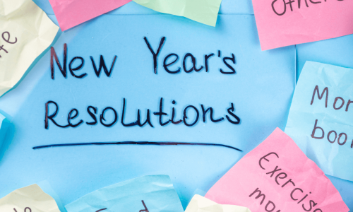 Handwritten New Year's resolutions on colorful sticky notes surrounding a blue background.